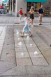 A girl runs through a fountain in Salzburg, Austria